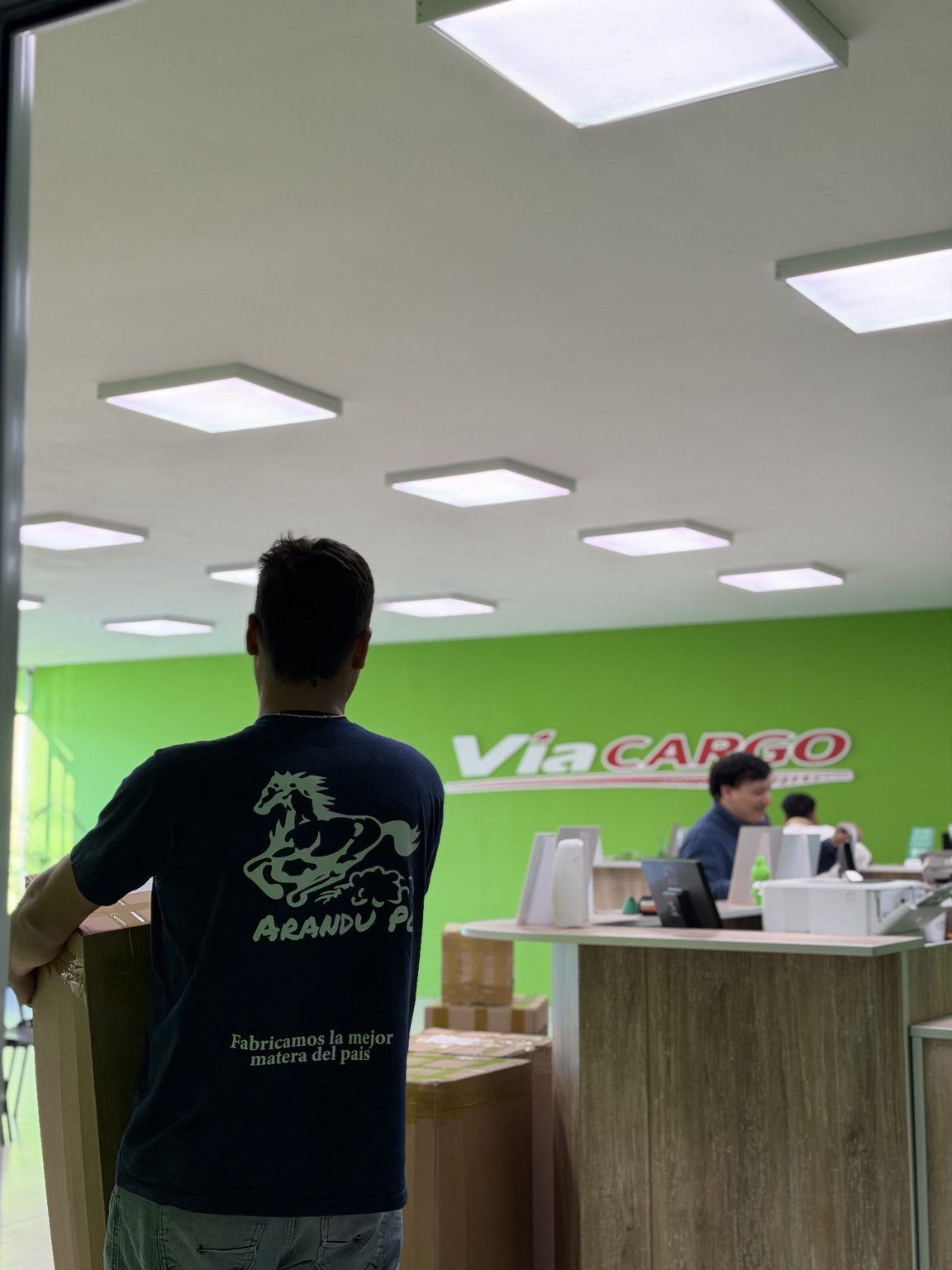 Integrante del equipo Arandu Po entregando cajas en una sucursal de Vía Cargo